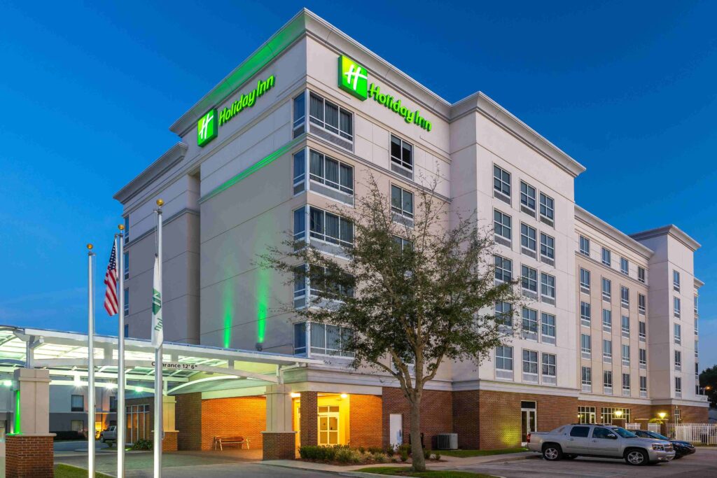 Holiday Inn hotel. Tan 6-story building with one tree.